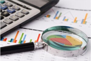 Magnifying glass over charts and graphs
